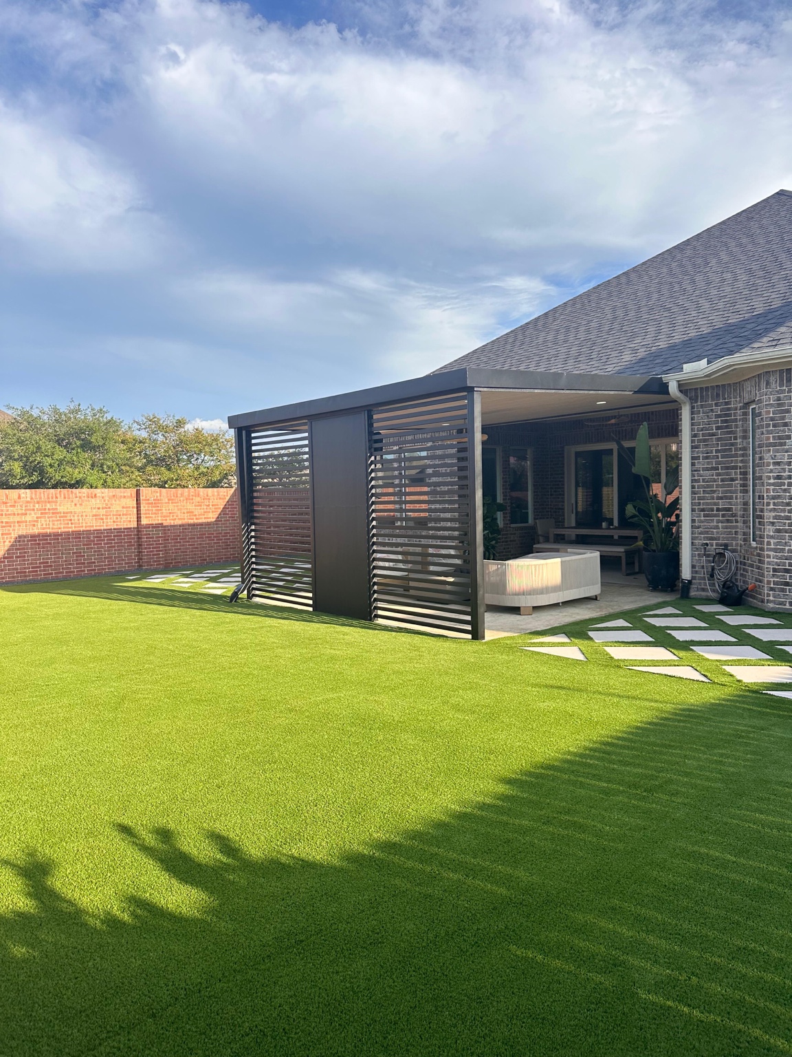 Backyard with artificial turf and modern cover