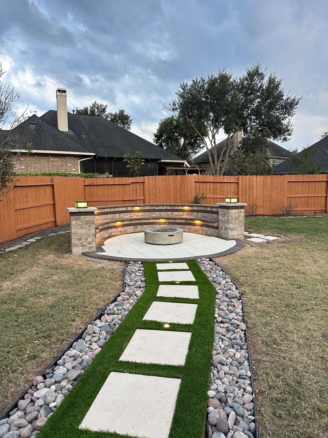 Curved fire pit with pathway and lighting