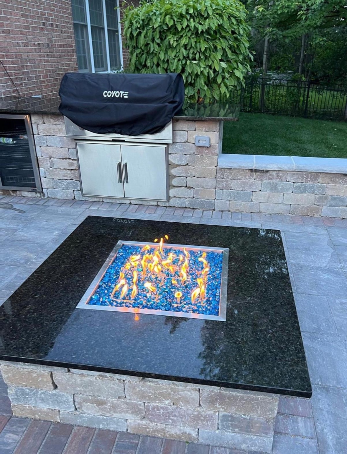 Square fire feature with blue glass and outdoor kitchen
